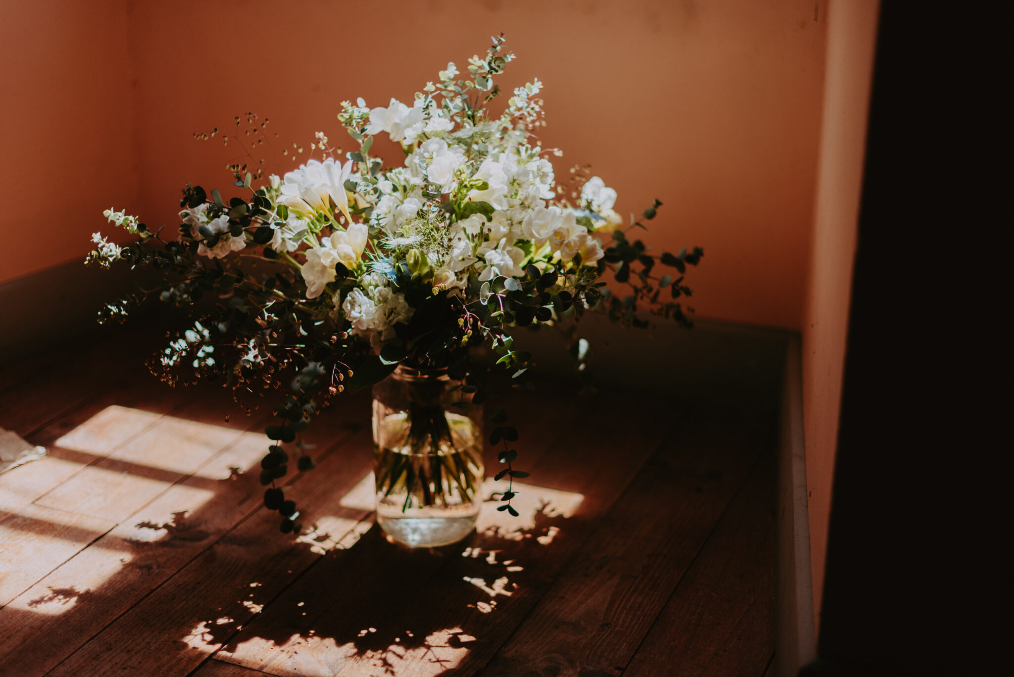 boquet de la marié photographier dans un vase transparent dans l'ombre d'une fenêtre