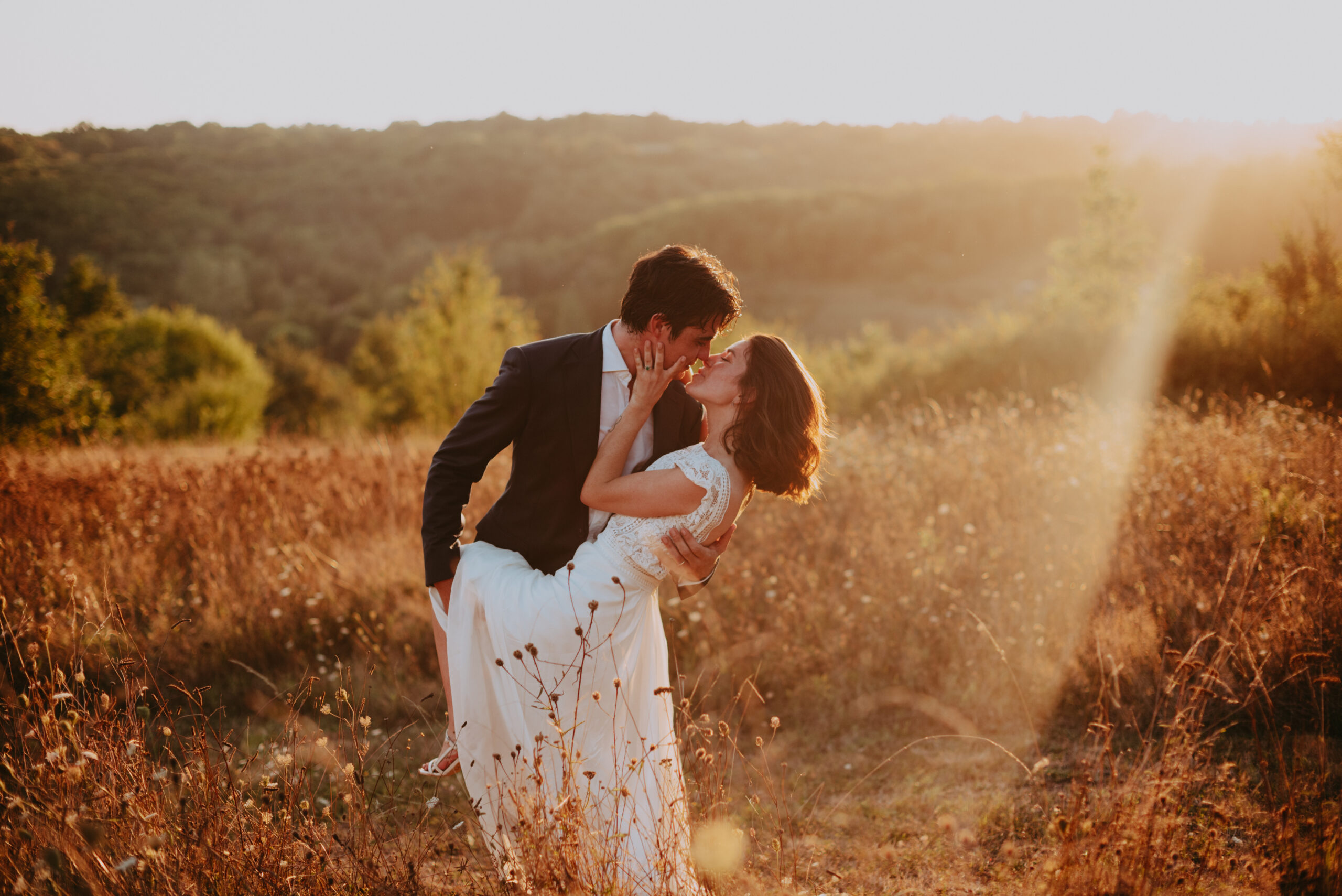 photo de couple qui s'embrasse au couchez de soleil