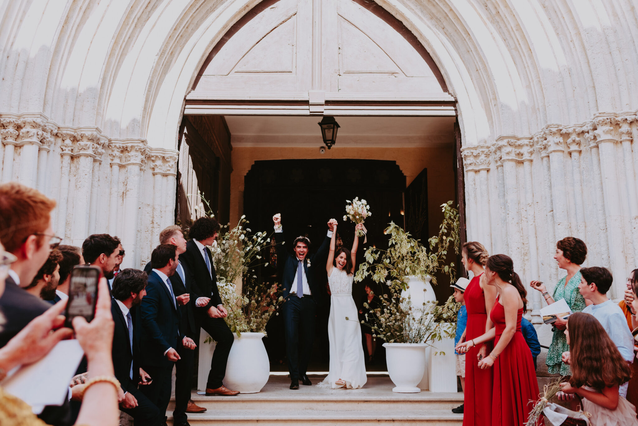 mariée qui sortent main dans la main de l'église en criant leur joie