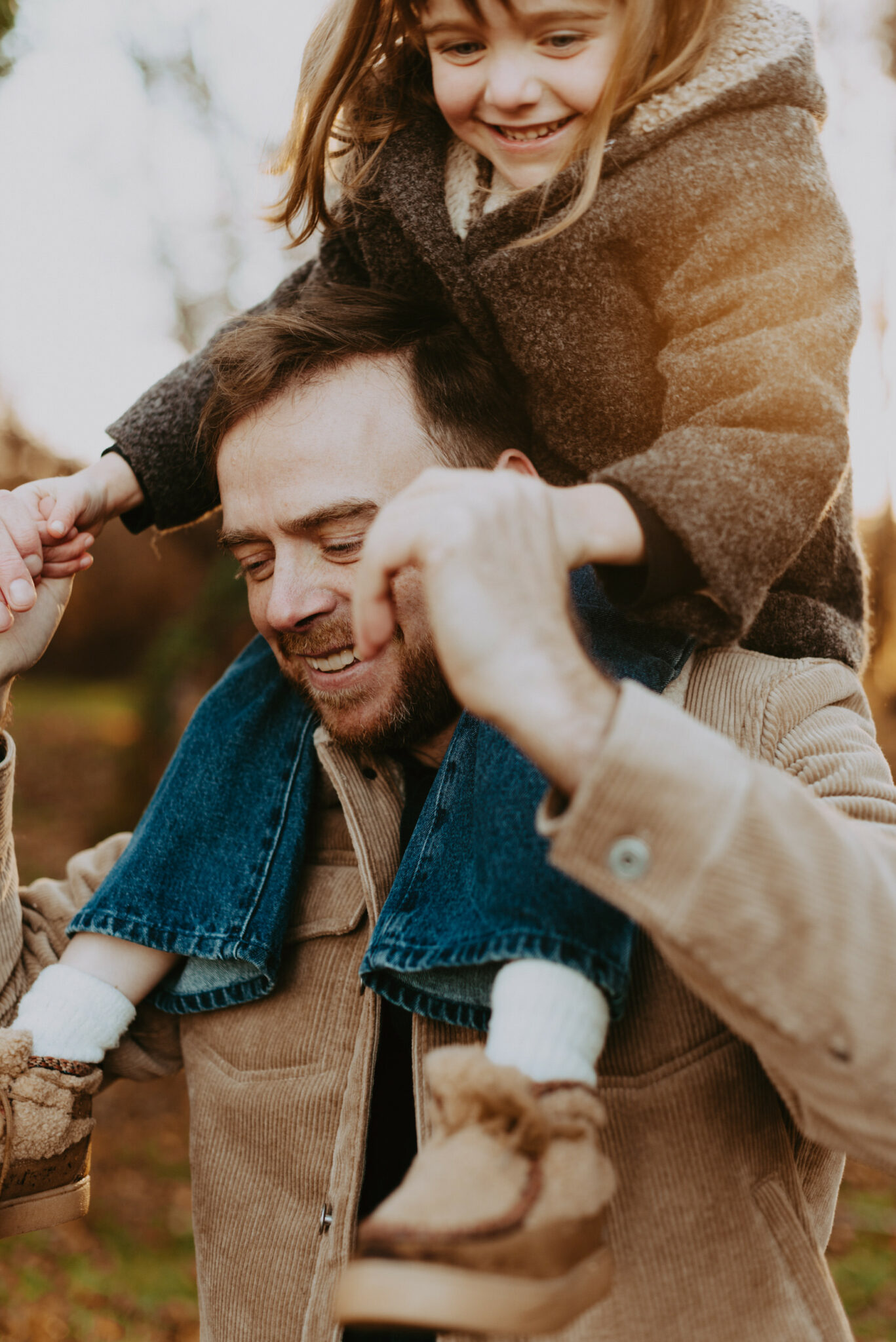 Photographe famille à Brive-la-gaillarde, papa qui porte sa petite fille sur les épaules et qui rient ensemble