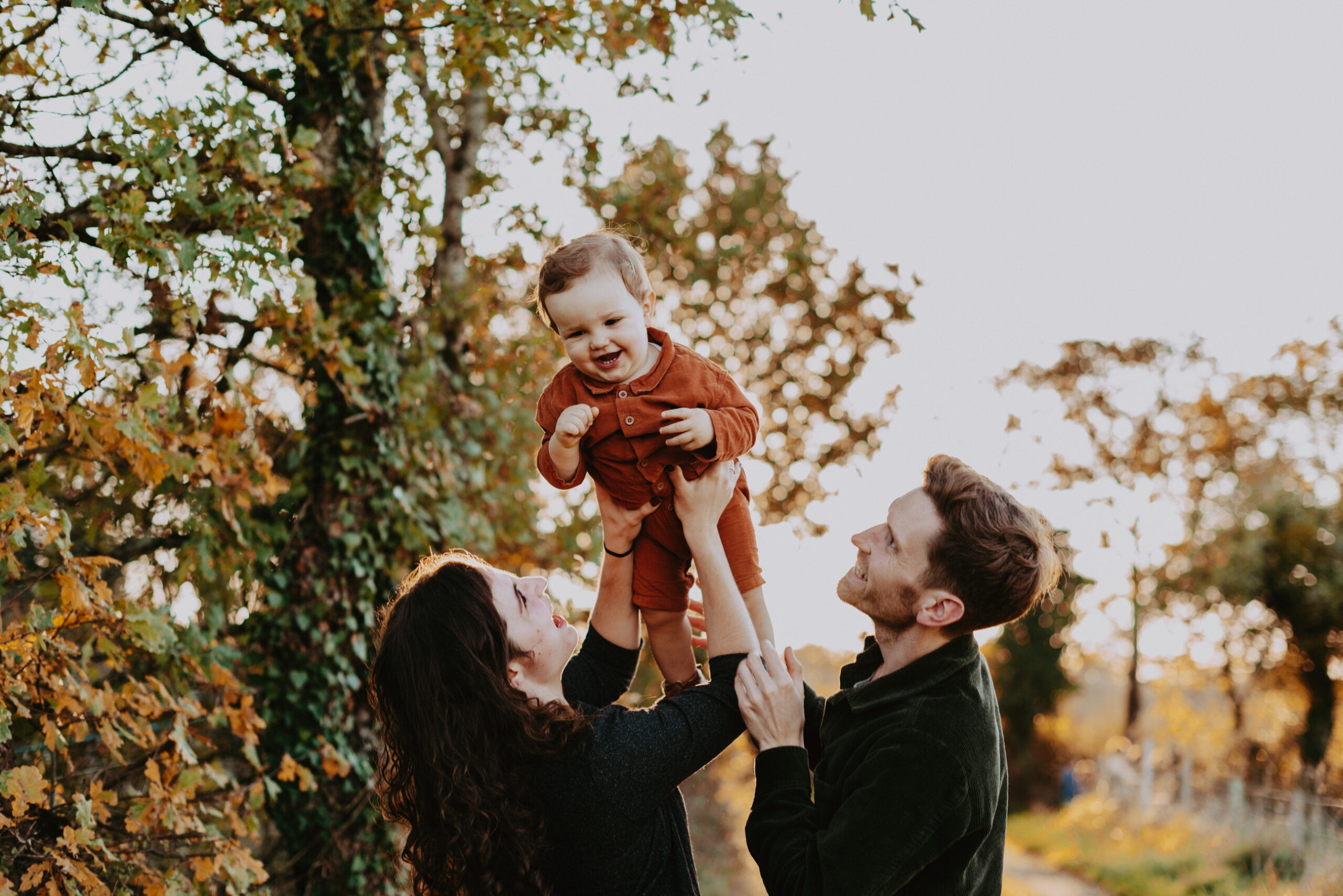 petit garçons que ses parents font sauter en l'air et qui rie aux éclats