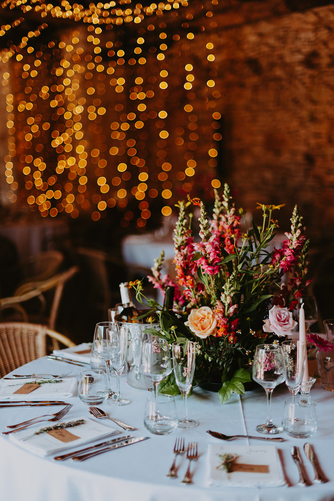 photo d'une table de mariage joliment décoré avec en fond un rideaux lumineux