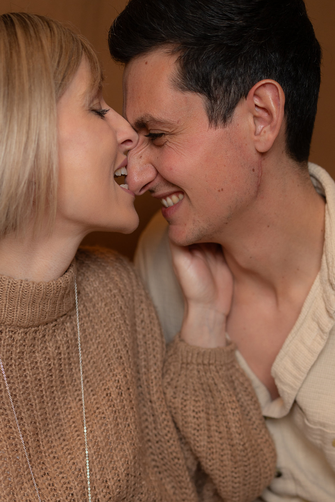 photo de couple d'une femme qui mord le bout du nez de son conjoint de manière drôle