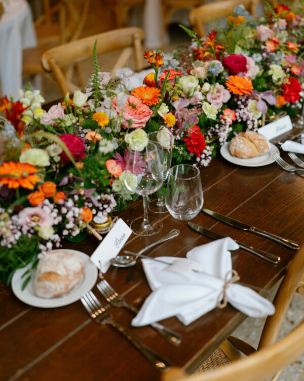 photo d'une table de mariage énormément fleurit de manière coloré
