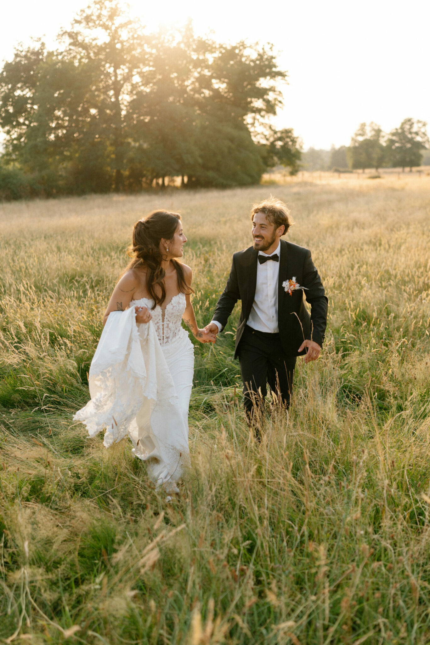 photo d'un couple qui court dans un champ au couchez de soleil